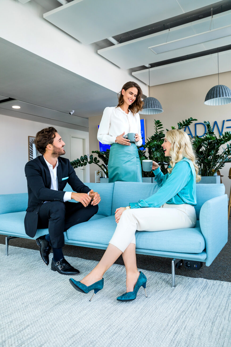 Besprechung 3er Kollegen auf einem blauen Sofa