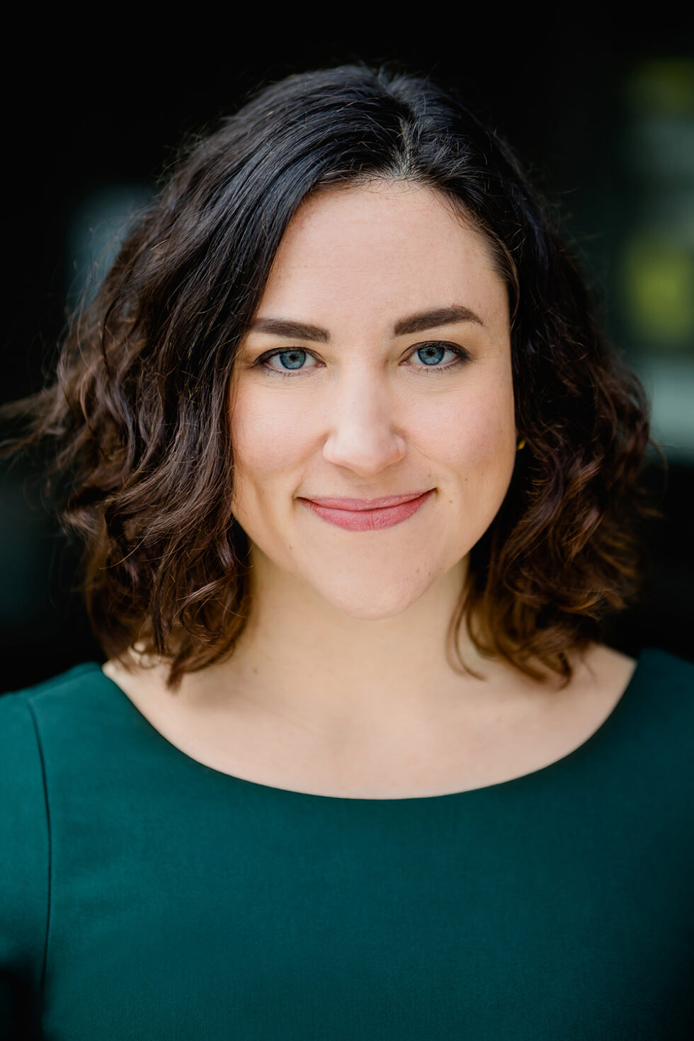 Bewerbungsfoto einer Frau mit farbigem Oberteil