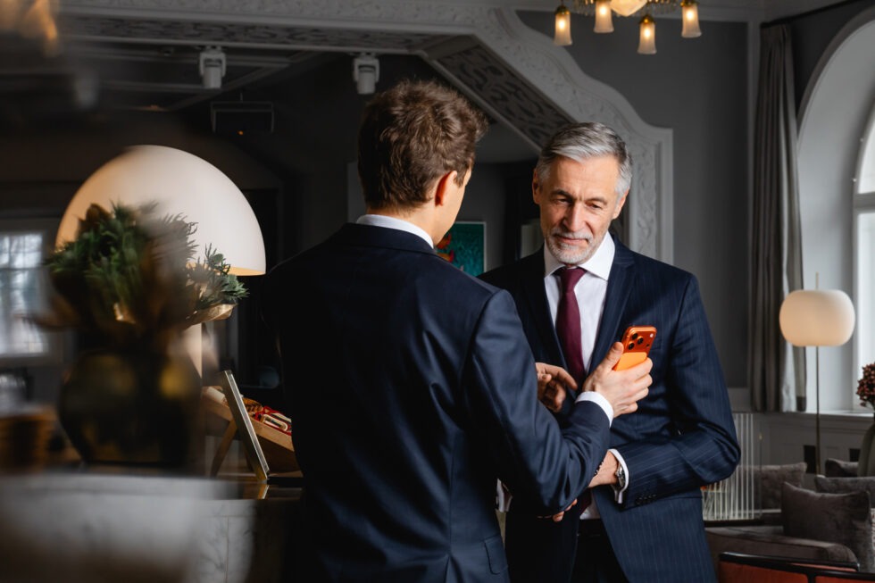 Mitarbeiter zeigt Kunde etwas auf dem Handy