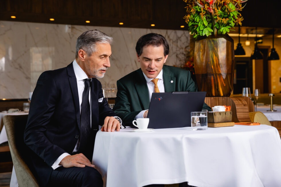 Mitarbeiter zeigt Kunde etwas auf dem Laptop