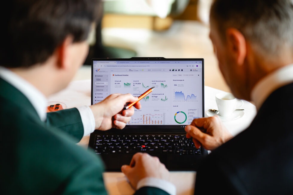 Mitarbeiter zeigt Kunde etwas auf dem Laptop