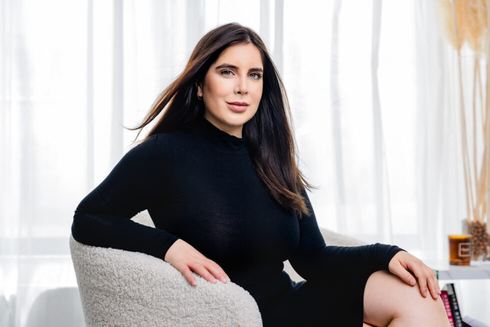 Businessportrait einer jungen Frau mit dunklen haaren, sie sitzt auf einem Sessel