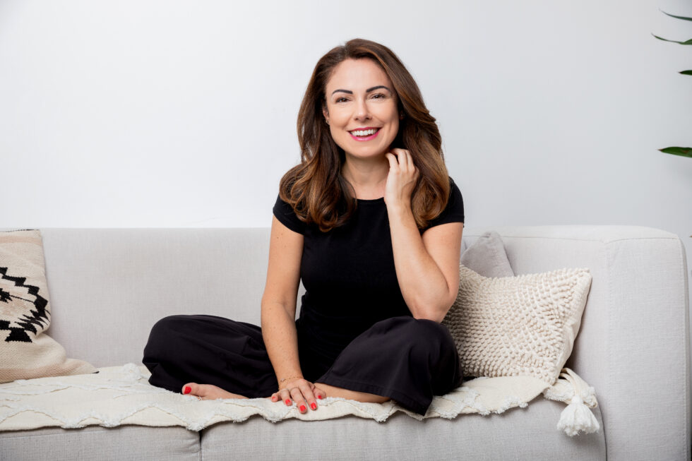 Portrait einer Frau die auf dem Sofa sitzt und lacht