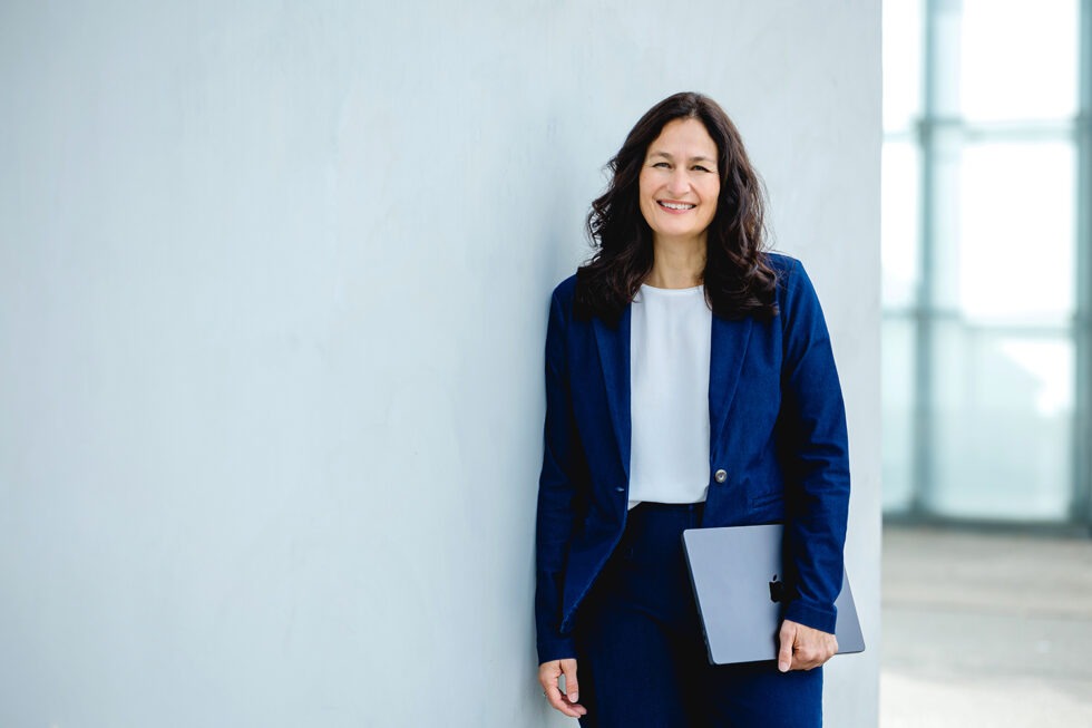 Business Portrait einer Frau mit blauem Anzug mit Laptop