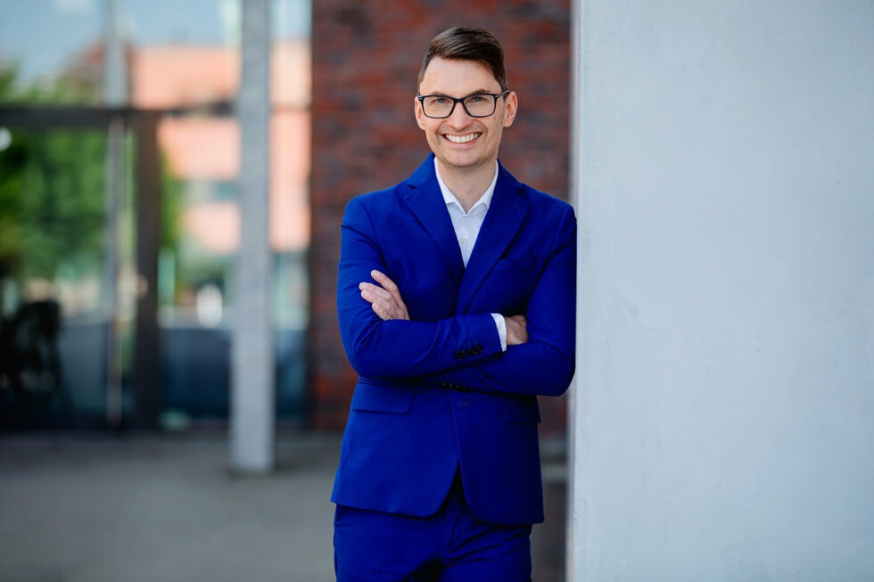 Business Foto eines Mannes mit Brille und blauem Anzug